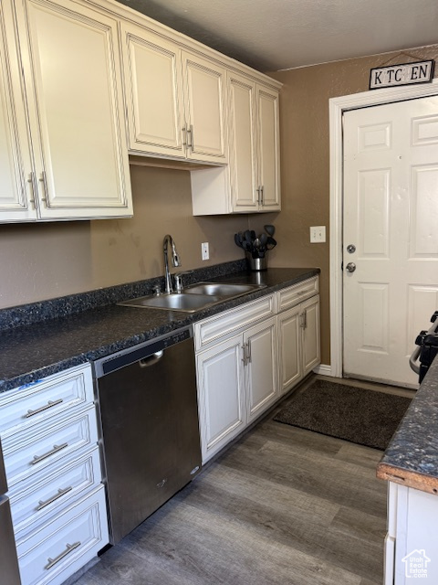 Kitchen featuring stainless steel dishwasher, dark wood finished floors, and dark countertops