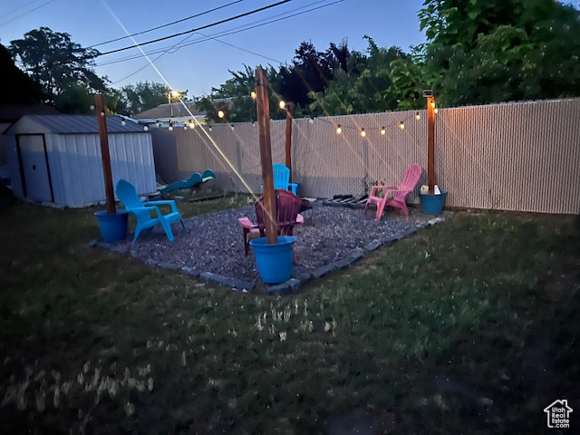 View of jungle gym featuring a fenced backyard and a storage shed