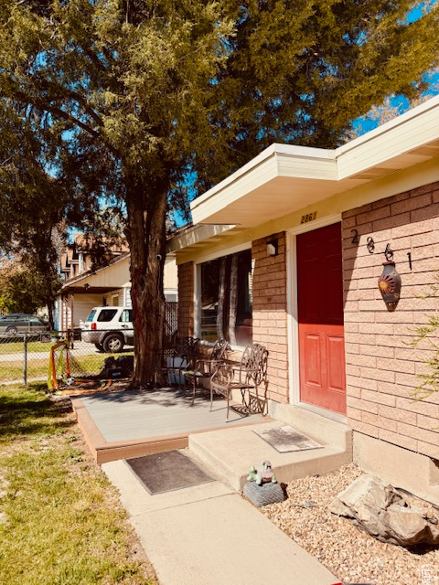 Property entrance with fence and brick siding