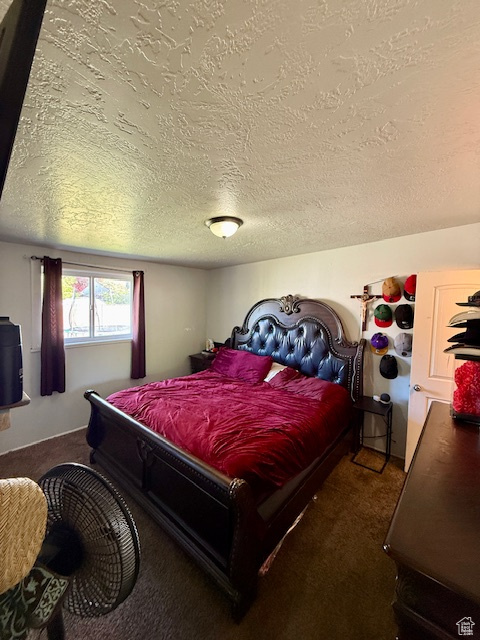 Bedroom featuring carpet floors and a textured ceiling