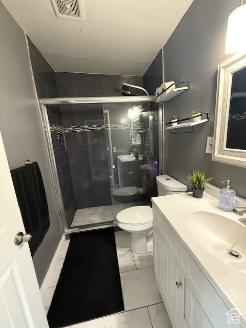 Full bathroom with marble look tile flooring, a shower stall, and vanity