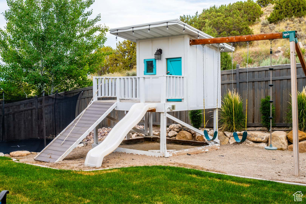 View of jungle gym with a fenced backyard