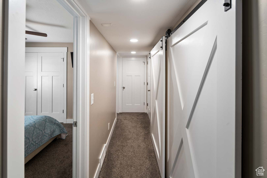 Corridor with baseboards, carpet flooring, recessed lighting, and a barn door