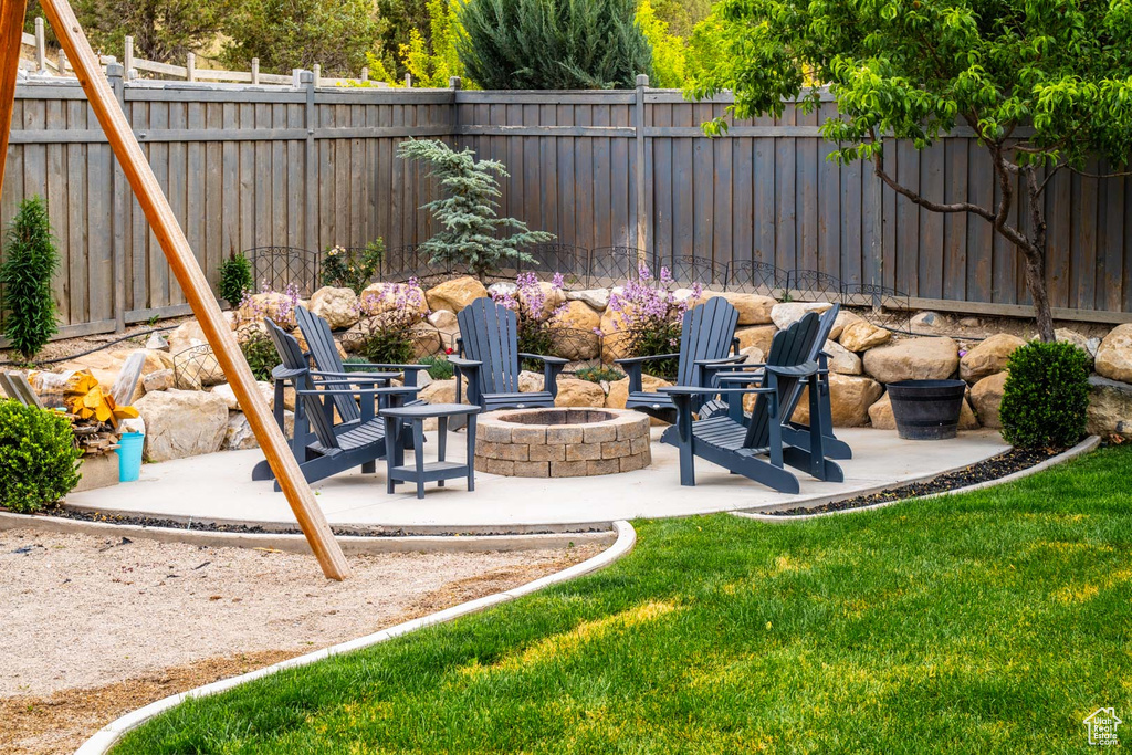 Fenced backyard with a fire pit and a patio area