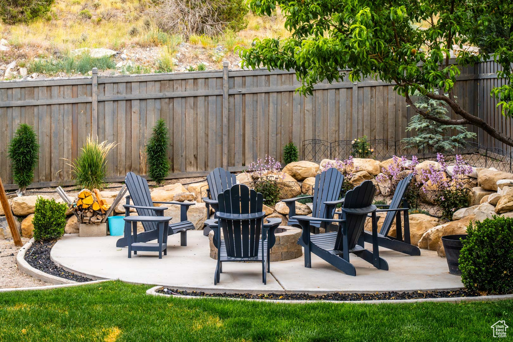 Fenced backyard with a fire pit and a patio area