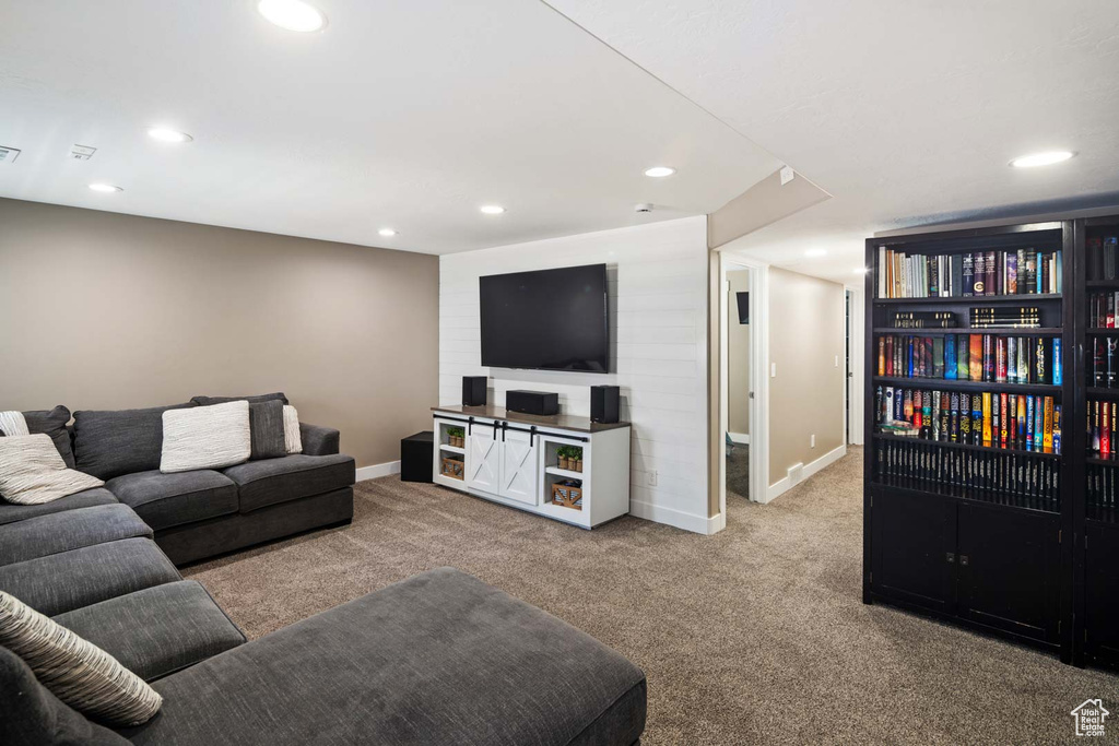Carpeted living area with recessed lighting and baseboards