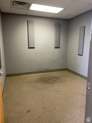 Empty room featuring baseboards, visible vents, and a paneled ceiling