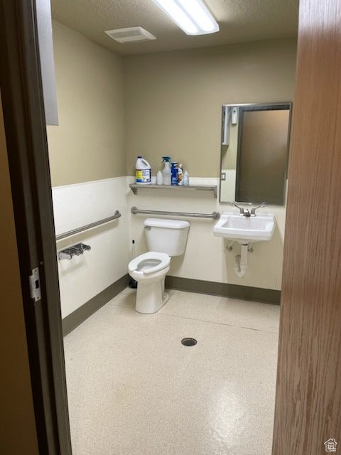 Bathroom featuring toilet, baseboards, and a sink
