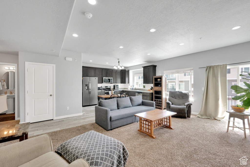 Living room featuring recessed lighting, baseboards, and a notable chandelier