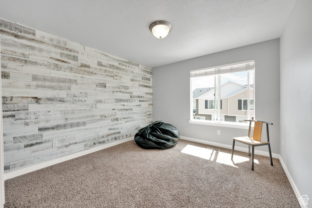 Unfurnished room with baseboards, an accent wall, and carpet flooring