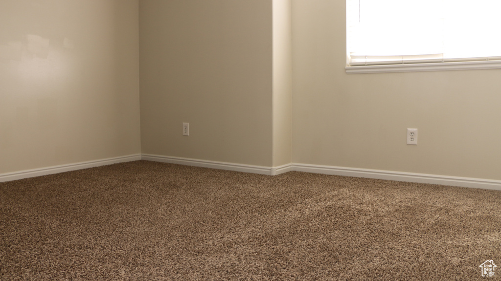 Carpeted empty room with baseboards