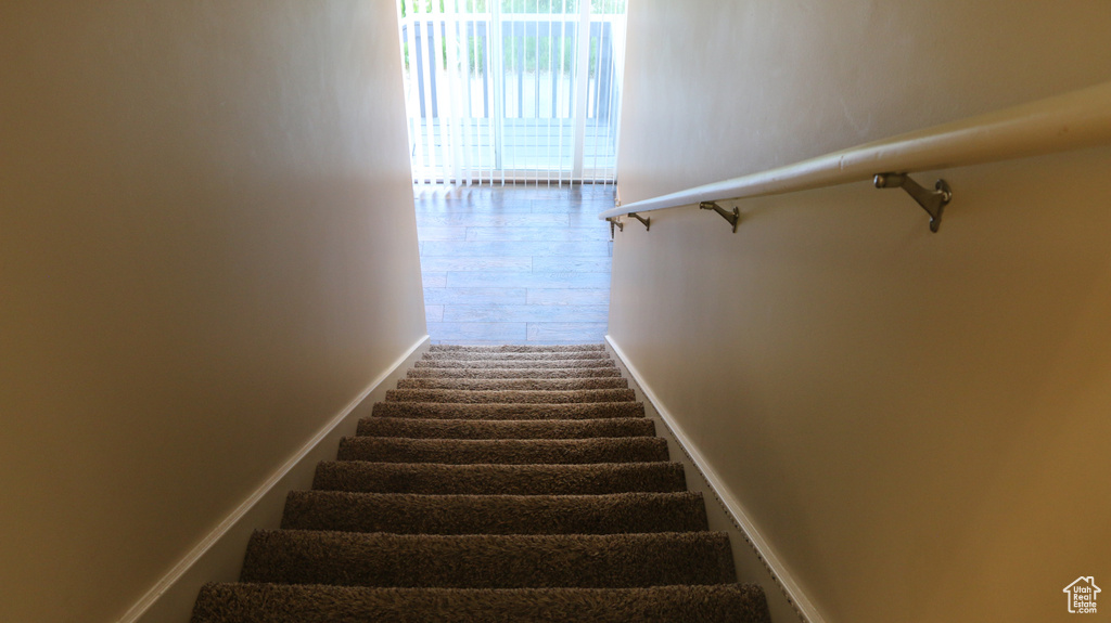 Stairway with baseboards and wood finished floors