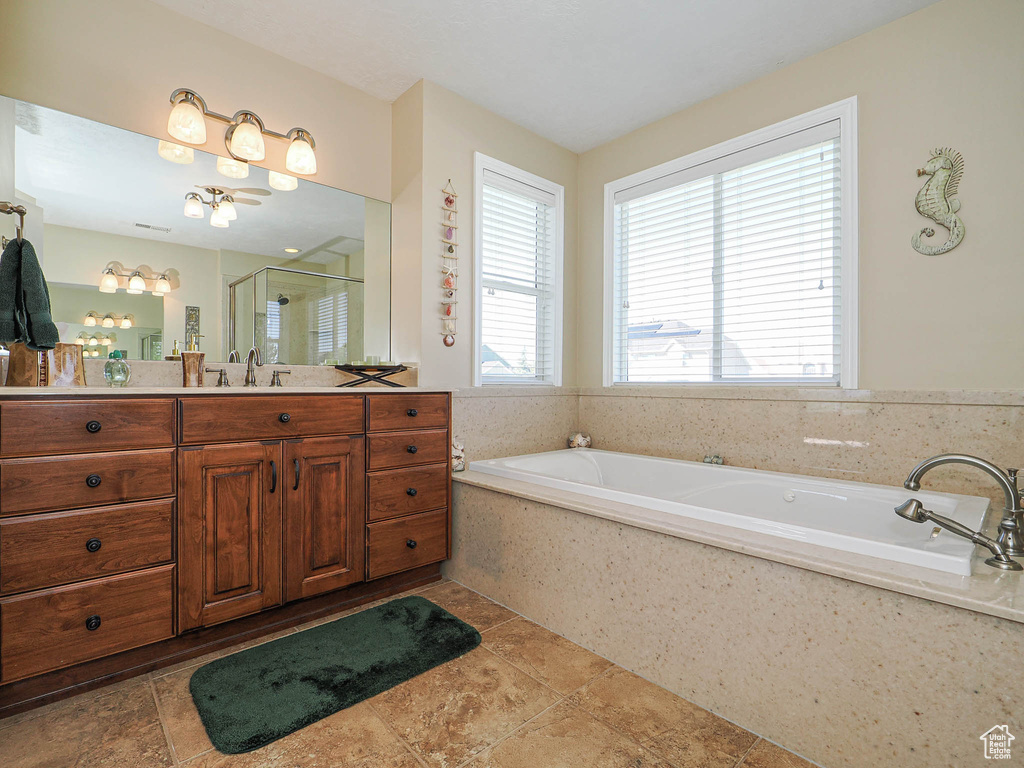 Full bath featuring vanity, a shower stall, and a garden tub