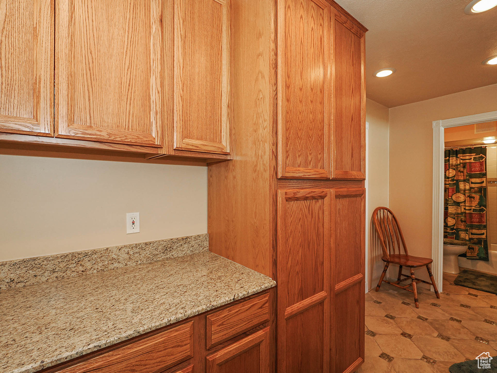 Kitchen featuring light stone counters and recessed lighting
