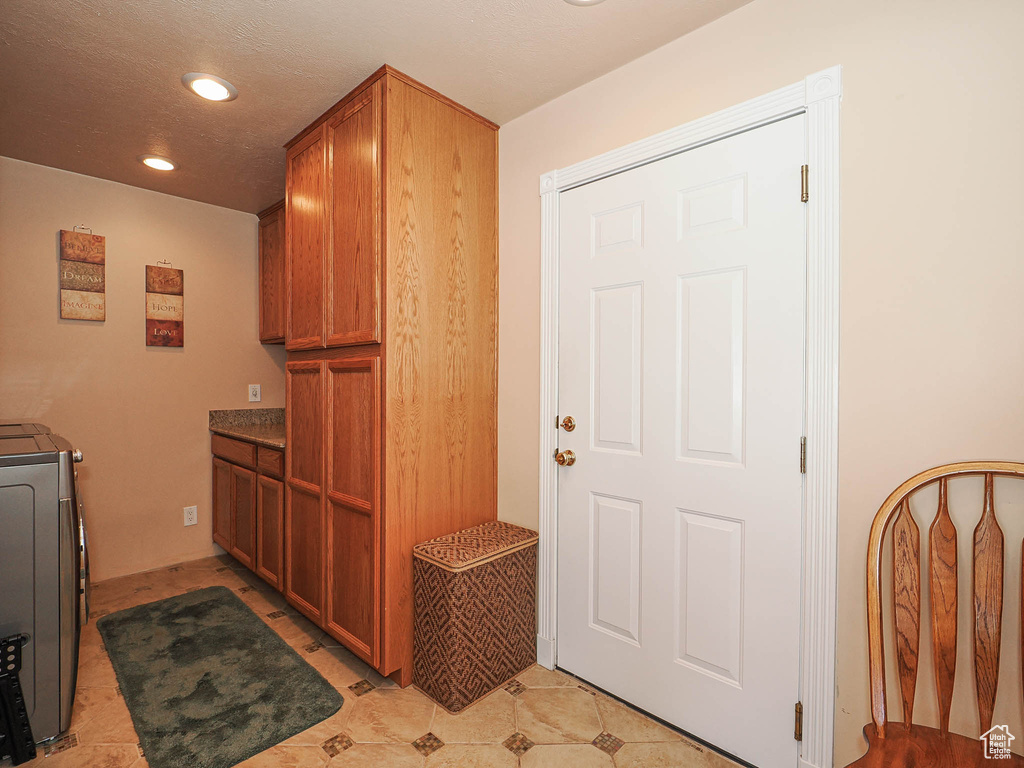 Clothes washing area with cabinet space, recessed lighting, and washer / dryer