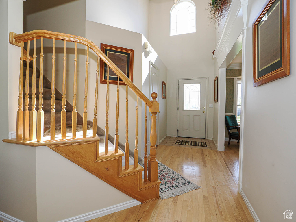 Foyer entrance featuring baseboards, stairs, a high ceiling, and hardwood / wood-style flooring