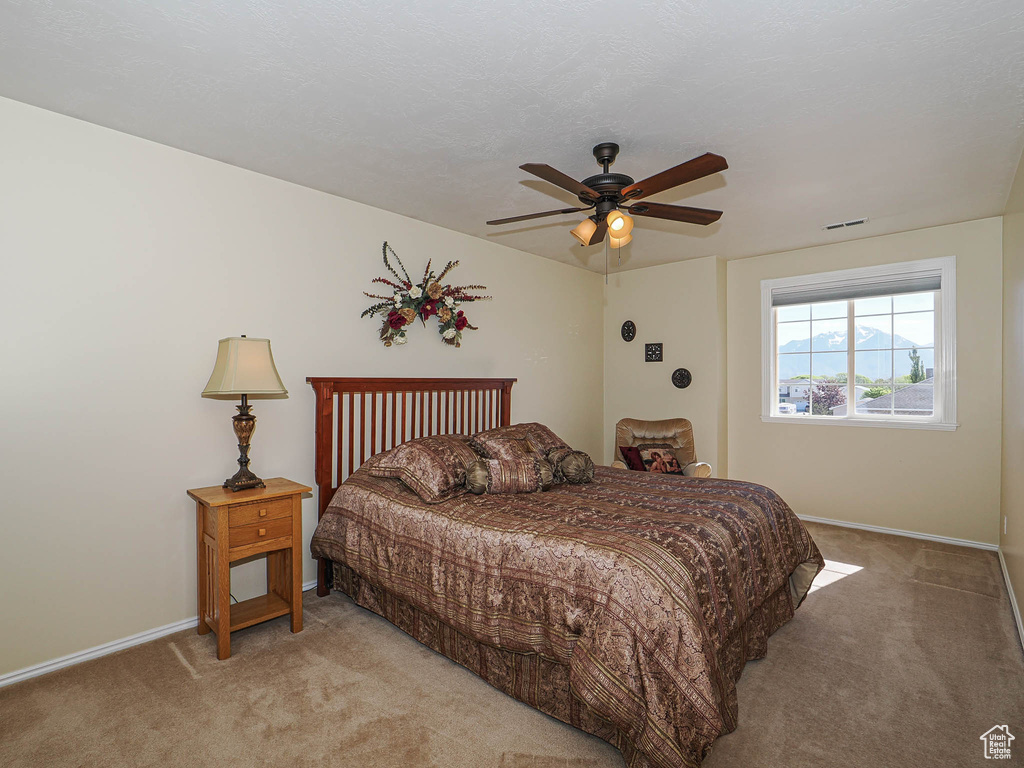 Bedroom featuring baseboards, light carpet, and a ceiling fan