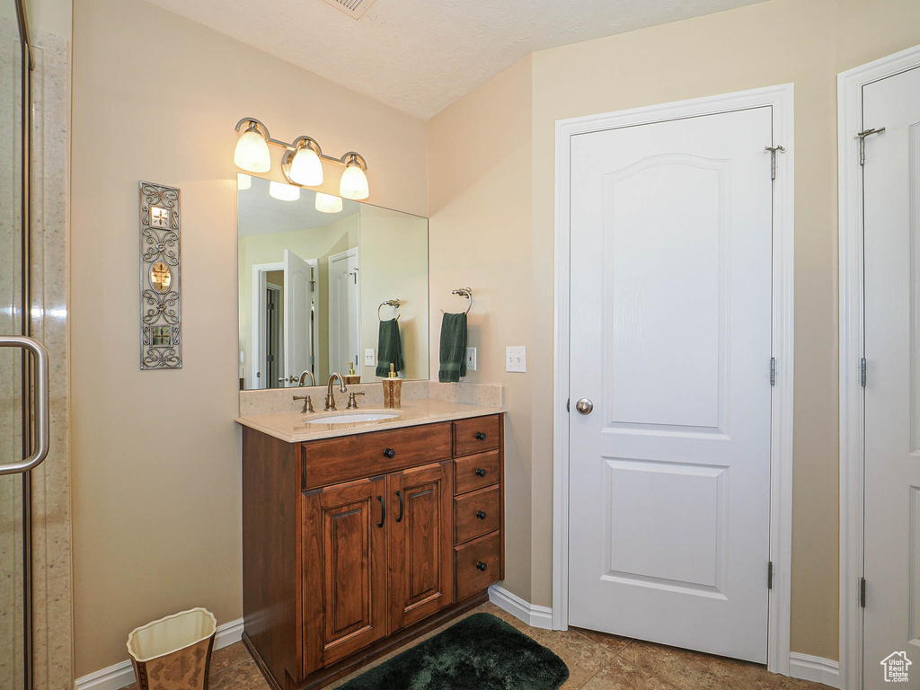 Bathroom with baseboards, vanity, and tile patterned floors