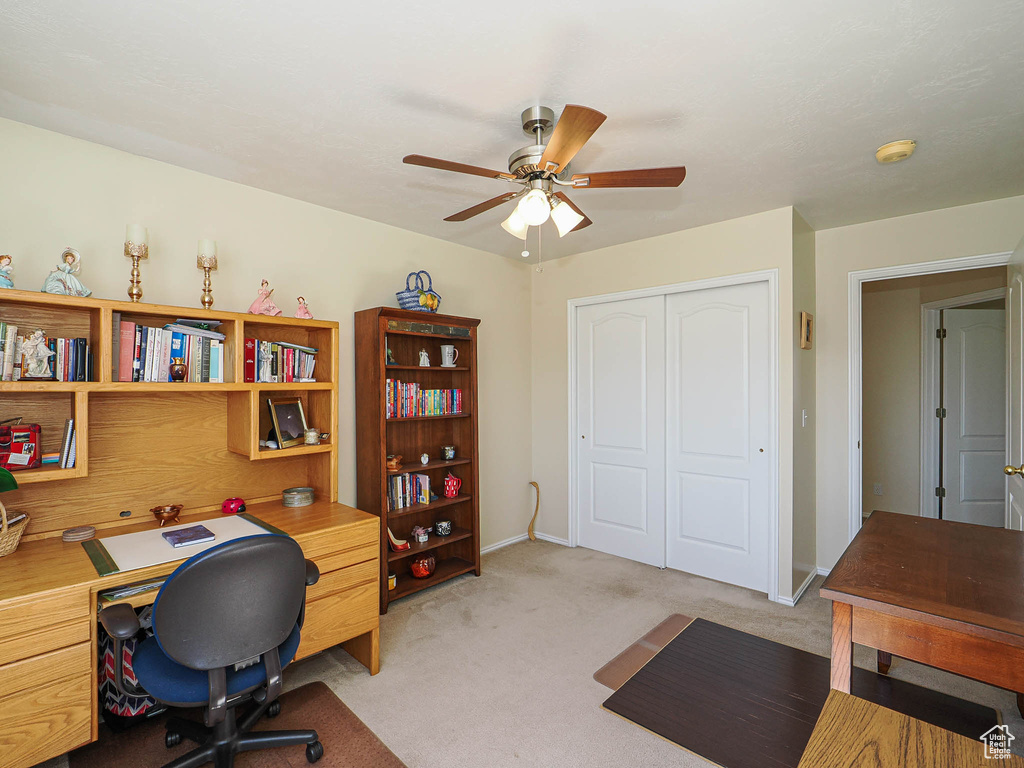 Office area featuring ceiling fan, light carpet, and baseboards