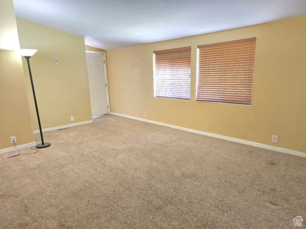 Unfurnished room featuring vaulted ceiling, baseboards, and carpet flooring