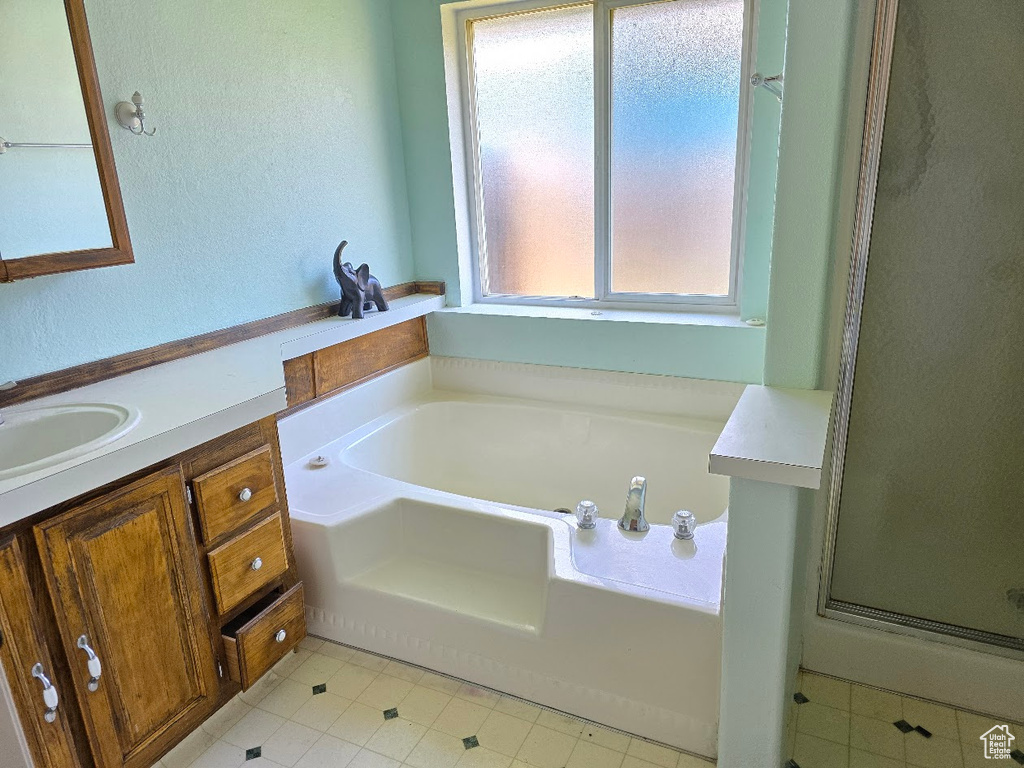 Full bathroom with a garden tub, tile patterned flooring, a stall shower, and vanity