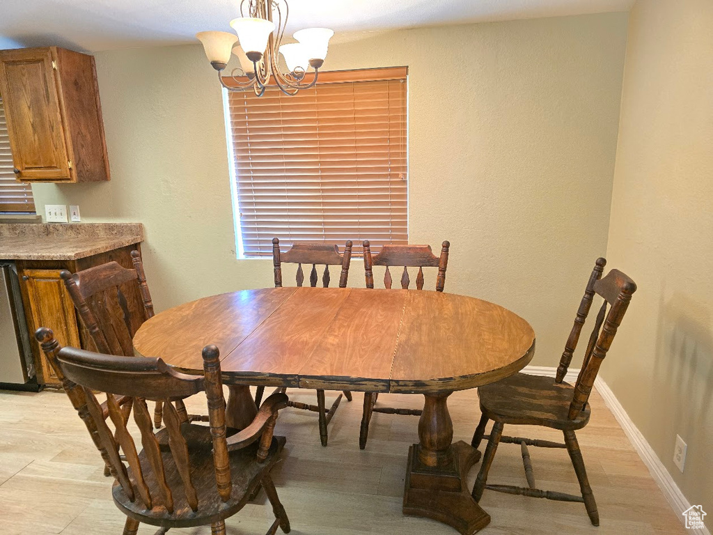 Dining space featuring baseboards, a textured wall, and a chandelier