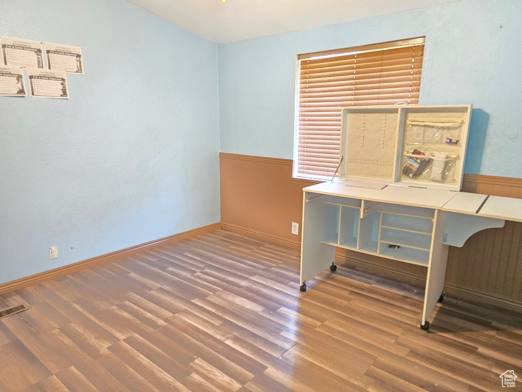 Empty room with visible vents, baseboards, and wood finished floors