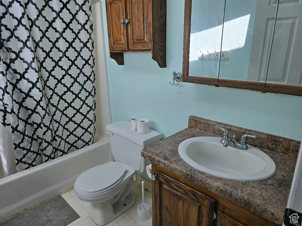 Bathroom featuring toilet, shower / bath combination with curtain, and vanity