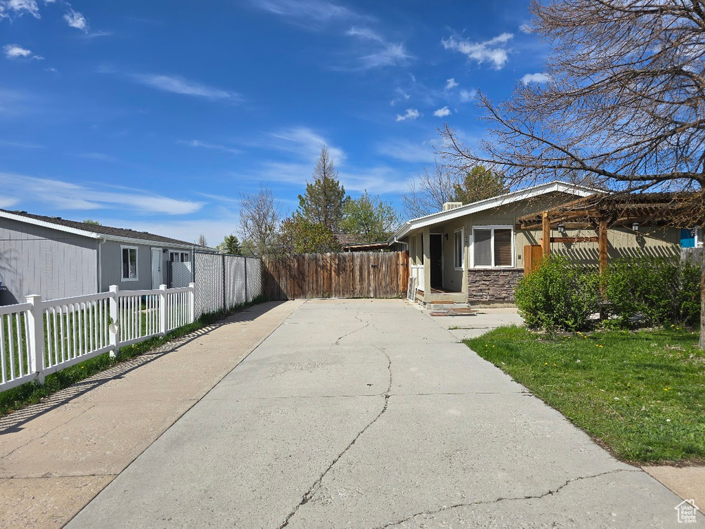 View of side of home with fence, a yard, and stone siding
