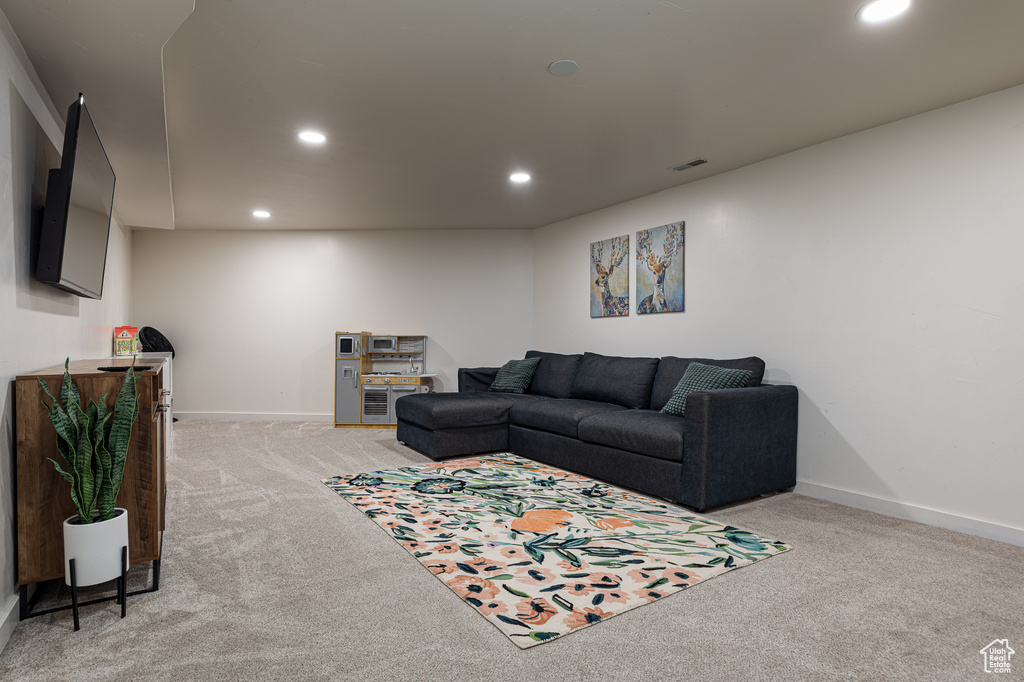 Living area with recessed lighting, baseboards, light colored carpet, and visible vents