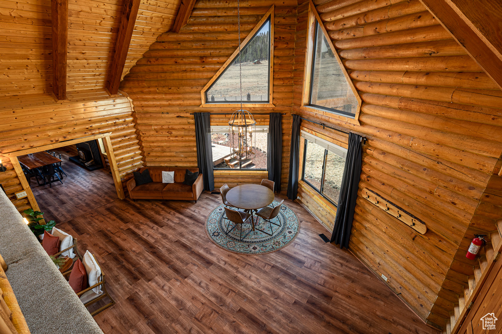 Living room with wood finished floors, log walls, beam ceiling, and wood ceiling