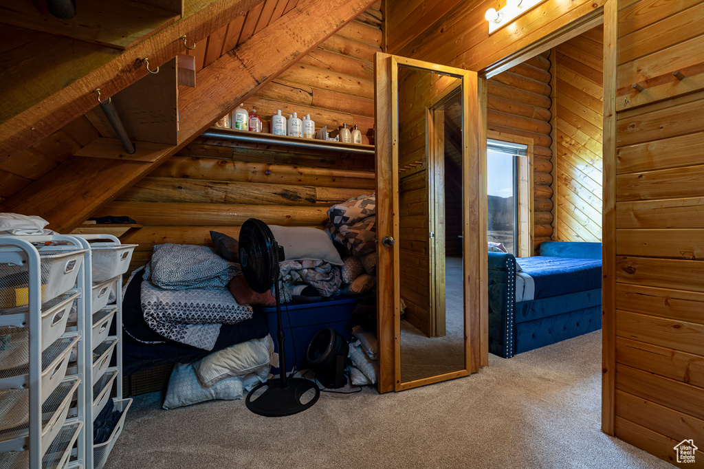 Bedroom with carpet and rustic walls