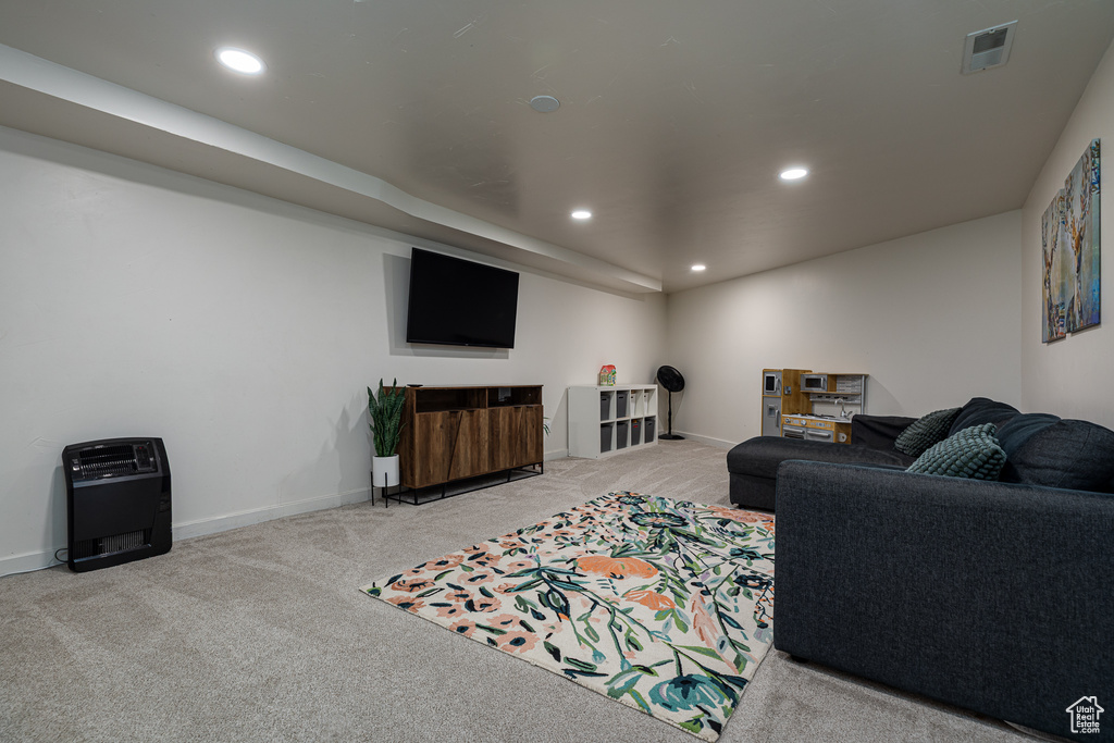 Carpeted living area featuring baseboards, recessed lighting, and visible vents