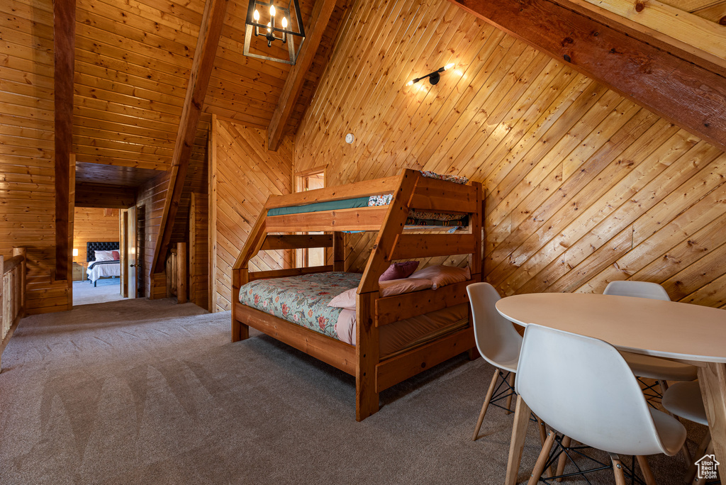 Bedroom featuring vaulted ceiling with beams, wood walls, and carpet flooring