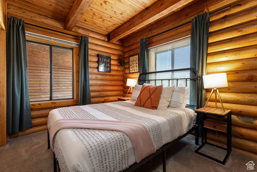 Carpeted bedroom featuring wood ceiling, rustic walls, and beamed ceiling