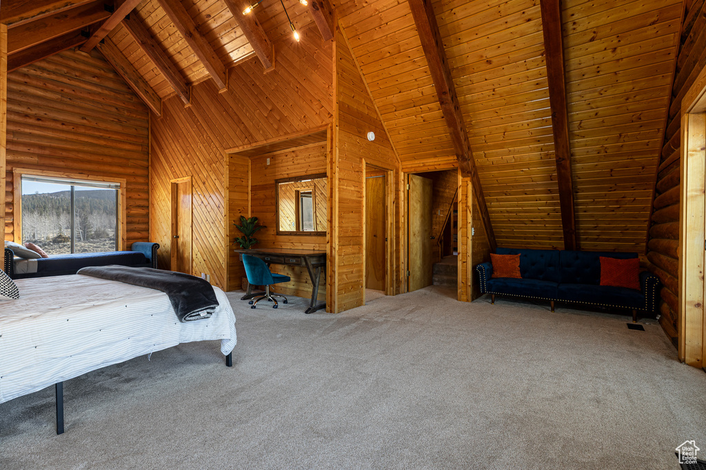 Carpeted bedroom with wood walls, wood ceiling, beam ceiling, and high vaulted ceiling