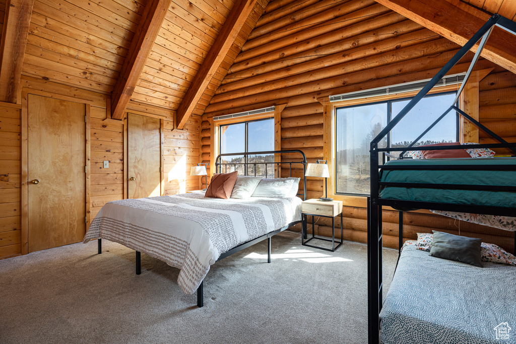 Bedroom with beam ceiling, log walls, wood ceiling, and carpet
