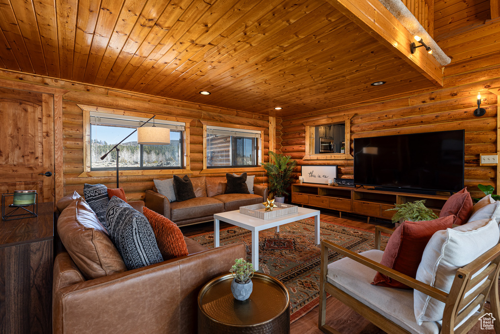 Living area featuring wood ceiling, track lighting, log walls, and wood finished floors