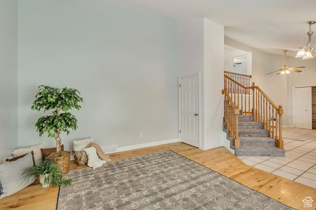 Interior space with stairway, baseboards, a ceiling fan, and wood finished floors