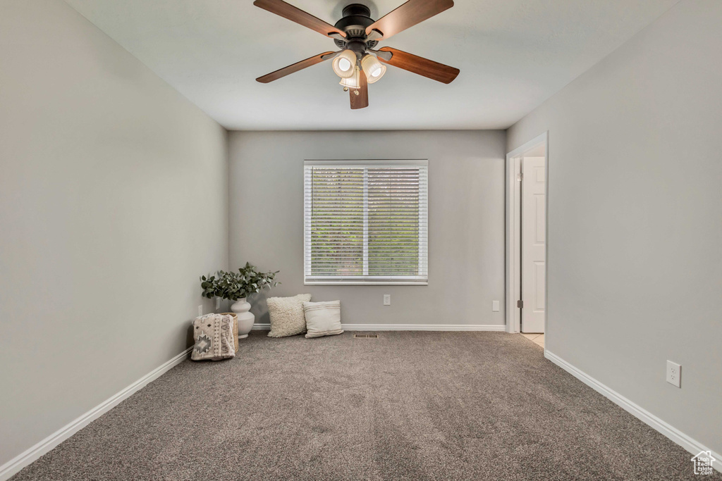 Unfurnished room with carpet floors, baseboards, and a ceiling fan