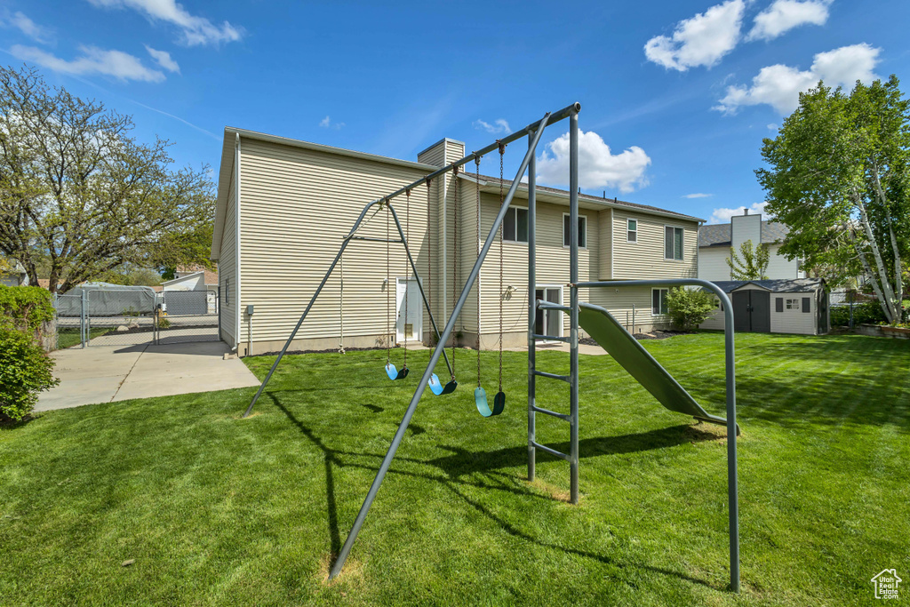 Rear view of property featuring an outdoor structure, fence, a shed, a chimney, and a yard