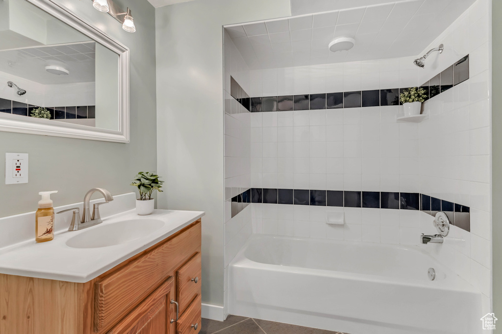 Bathroom with washtub / shower combination, tile patterned flooring, and vanity