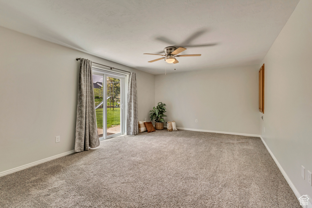 Carpeted empty room with baseboards and ceiling fan