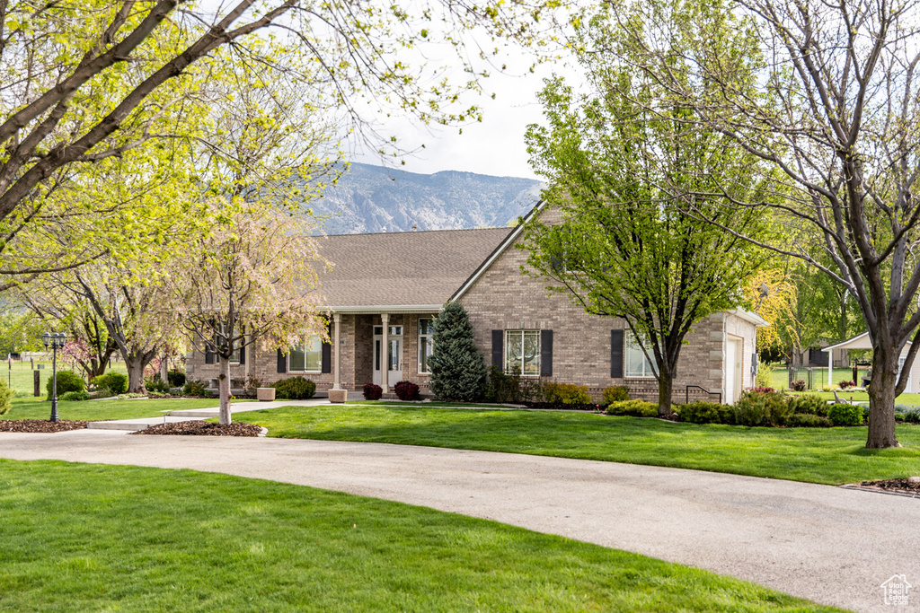 Ranch-style house with brick siding, a mountain view, and a front yard