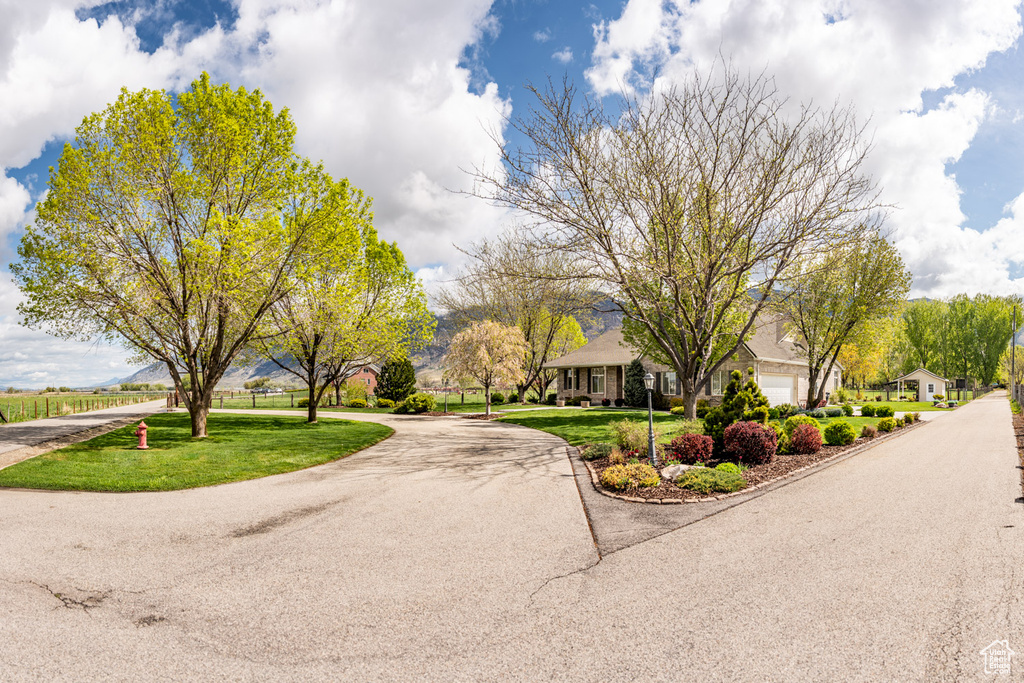 View of community with an attached garage, aphalt driveway, and a yard