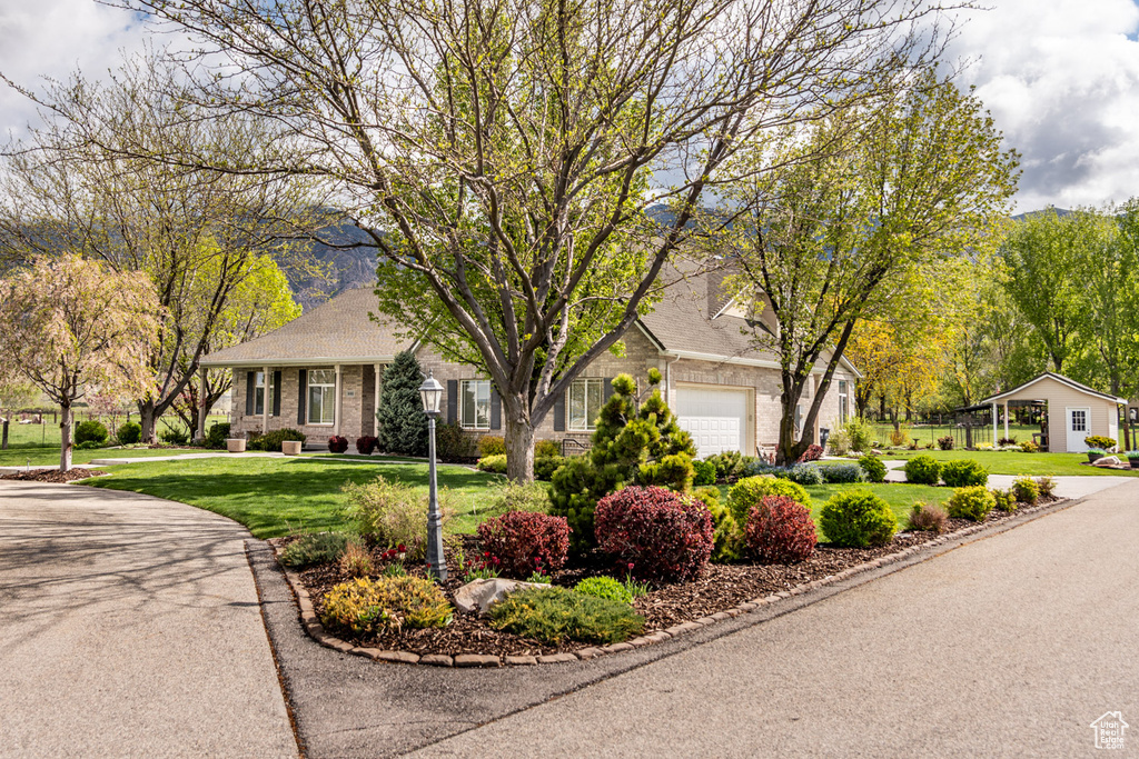 Ranch-style house featuring a garage, a front lawn, and brick siding
