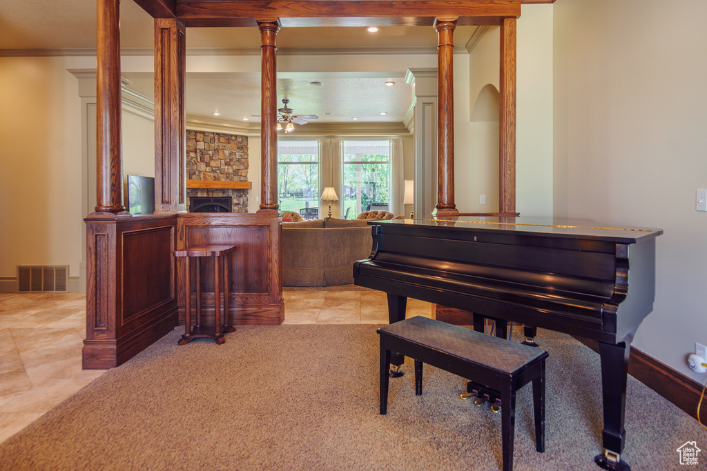 Sitting room with visible vents, ornamental molding, a fireplace, a ceiling fan, and light tile patterned floors