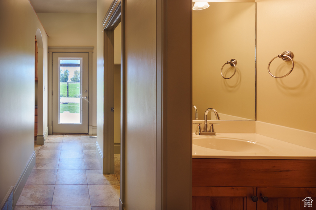 Bathroom with baseboards, tile patterned flooring, and vanity