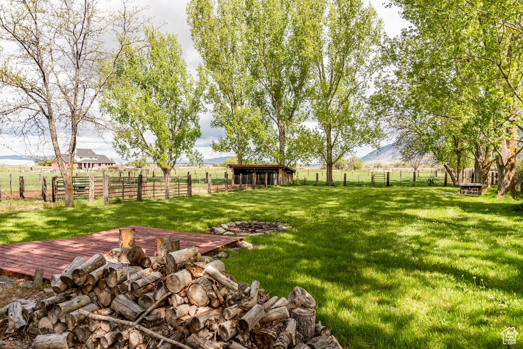 View of yard featuring a fire pit, fence, and a rural view