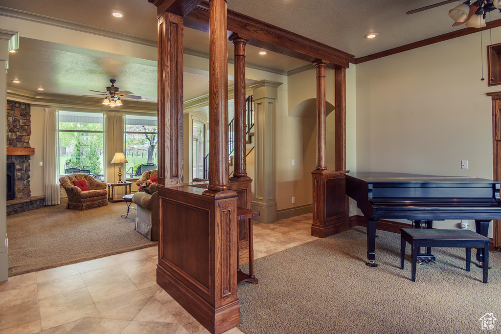 Office with ornate columns, ornamental molding, ceiling fan, and light carpet